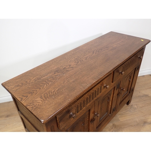 100 - An oak Sideboard fitted two frieze drawers above three arch carved cupboard doors 4ft W x 2ft 8in H