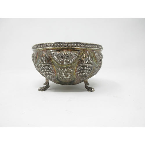 103 - An Oriental silver Bowl, embossed and chased with fish, animals and leafage on paw feet, 4in diam