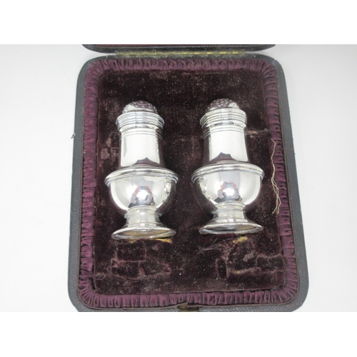 114 - A pair of George V silver Pepperettes of urn shape, Chester 1924, in case