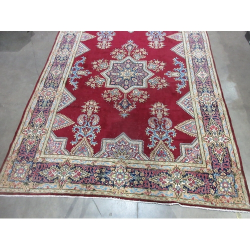 298 - A Persian style Carpet of multi-bordered design with central star on a red ground, 13ft 4in x 9ft 8i... 