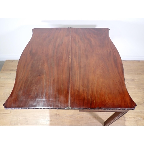 358 - A George III mahogany serpentine fronted fold-over Tea Table with floral carved edge and chamfered c... 