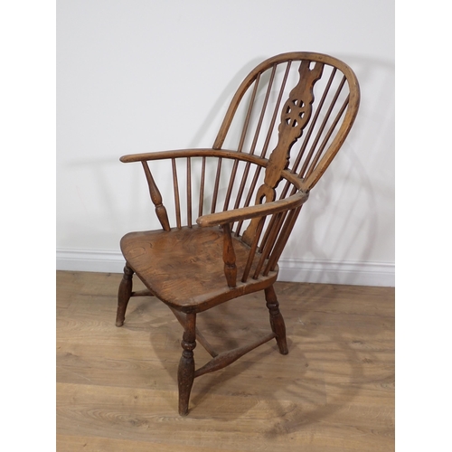 366 - A 19th Century ash and elm Windsor Elbow Chair with wheel pierced splat back on turned supports and ... 