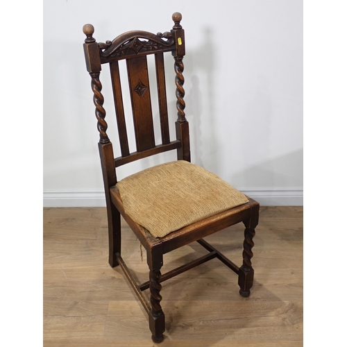 393 - An oak draw leaf Dining Table on barley twist supports, four Dining Chairs and a Court Cupboard