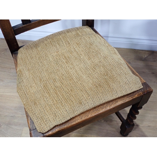 393 - An oak draw leaf Dining Table on barley twist supports, four Dining Chairs and a Court Cupboard