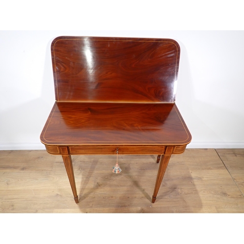 611 - A 19th Century mahogany and boxwood strung fold-over Tea Table mounted on square cut tapering suppor... 