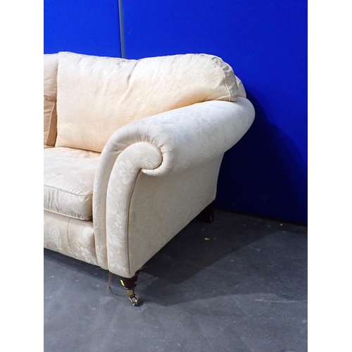 658 - A gold upholstered three seater Sofa on turned mahogany supports 7ft 3in W x 2ft 6in H