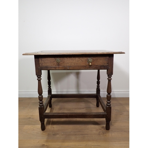 661 - An 18th Century oak Side Table with moulded top fitted frieze drawer mounted upon baluster turned su... 