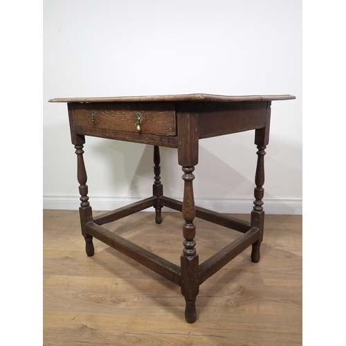 661 - An 18th Century oak Side Table with moulded top fitted frieze drawer mounted upon baluster turned su... 