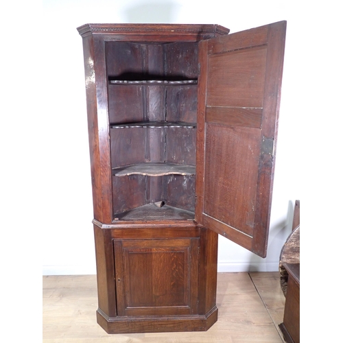 697 - A George III and later oak standing Corner Cupboard fitted two fielded panel doors beneath Greek key... 