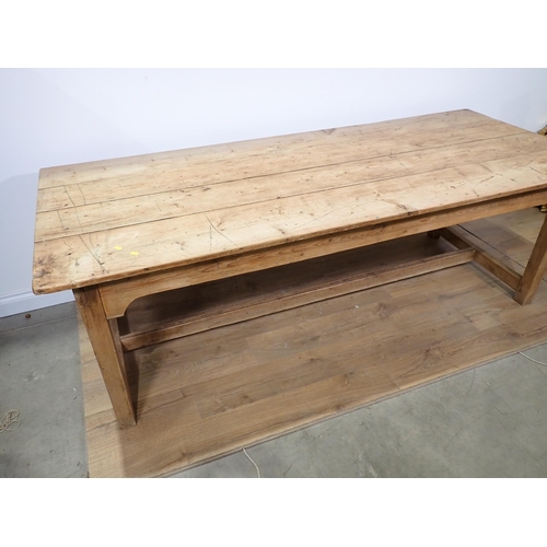 570 - A 19th Century pine Farmhouse Table with four plank top mounted upon square cut supports united by H... 