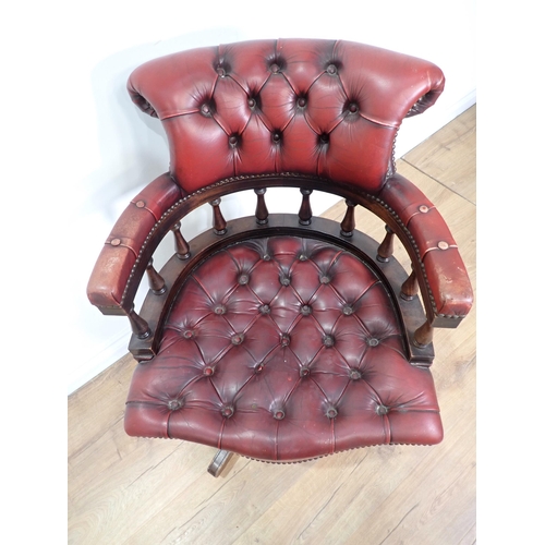 584 - A red leather upholstered swivel Office Chair on mahogany supports