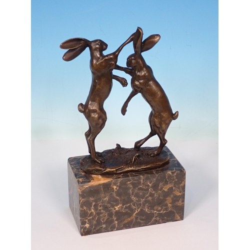 6 - A bronze Sculpture of boxing hares on green polished stone base, signed 'Nick' 9 1/2in H