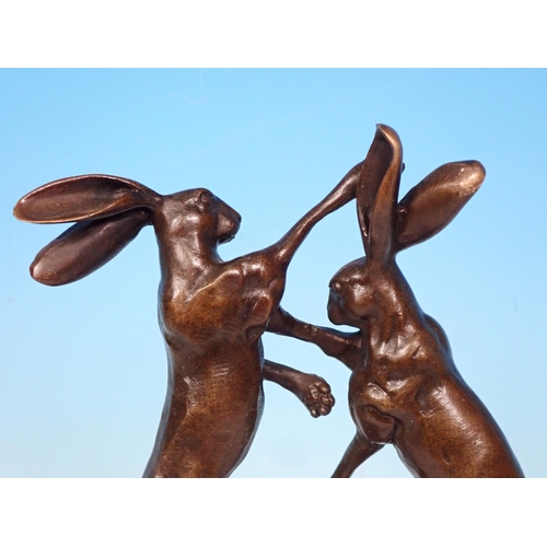 6 - A bronze Sculpture of boxing hares on green polished stone base, signed 'Nick' 9 1/2in H