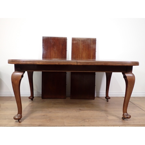 603 - An Edwardian mahogany extending Dining Table with two spare leaves mounted upon cabriole supports an... 