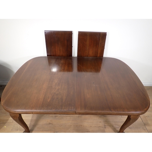 603 - An Edwardian mahogany extending Dining Table with two spare leaves mounted upon cabriole supports an... 