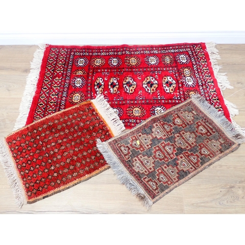 68 - A red ground woollen Rug 3ft 11in L x 2ft 5in W and two small Mats