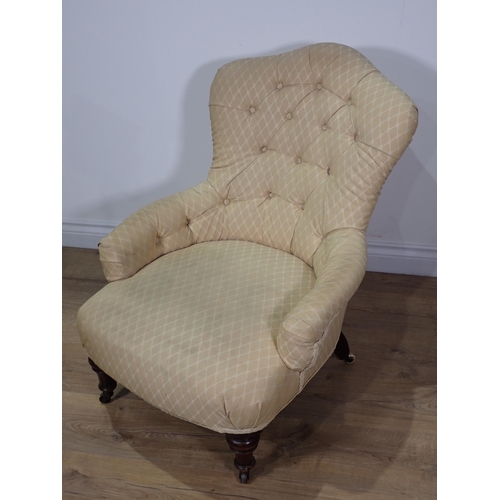 96 - A Victorian peach button upholstered Armchair on mahogany turned supports and casters