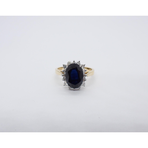 161 - A Sapphire and Diamond Cluster Ring claw-set oval-cut sapphire, 3.31cts, within a frame of brilliant... 