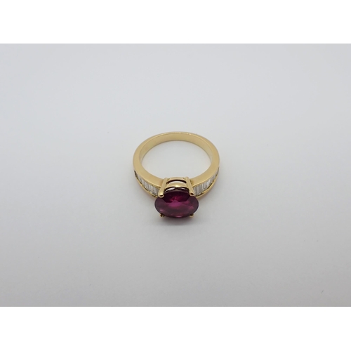 164 - A Ruby and Diamond Ring claw-set round ruby, 3.24cts, between channel-set graduated diamond baguette... 