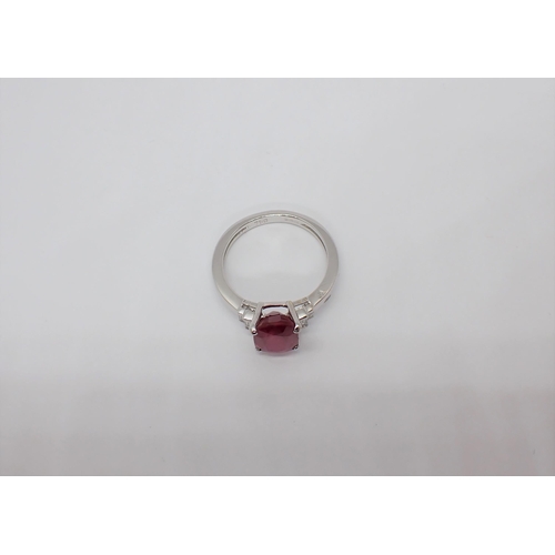 168 - A Ruby and Diamond Ring claw-set oval-cut ruby between two pairs of diamond baguettes in 18ct white ... 