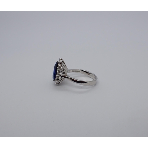 190 - A Sapphire and Diamond Cluster Ring claw-set fine pear-cut sapphire, 3.64cts, within a frame of bril... 