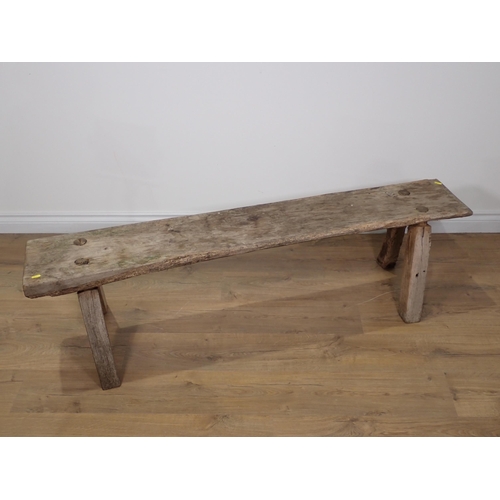 308 - An antique rustic Bench on square cut supports 4ft 10in W x 1ft 4in H