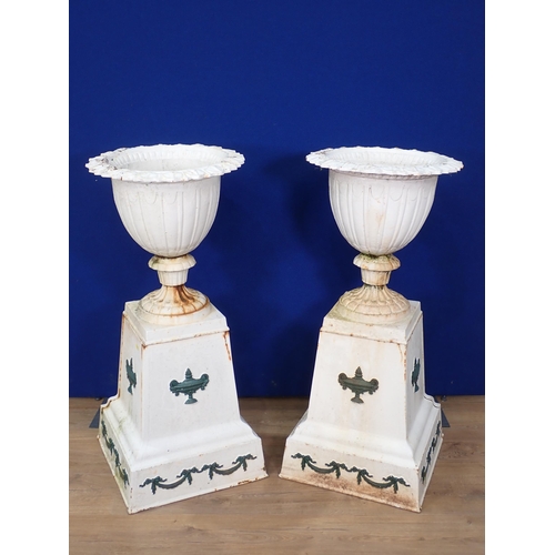 312 - A pair of antique white painted cast iron Urns on plinths with Regency Urn and Swag embossed design ... 