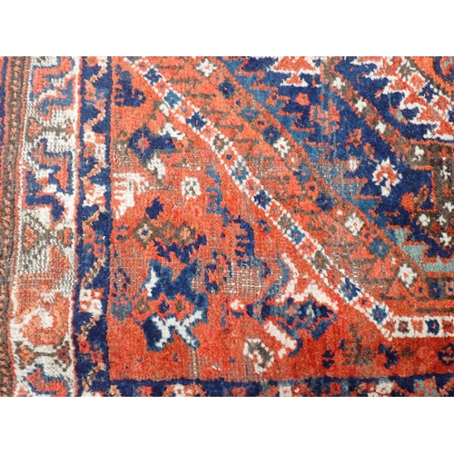 348 - A Persian Rug with multi-borders, stylised motifs and a central blue ground, 6ft x 4ft 10in