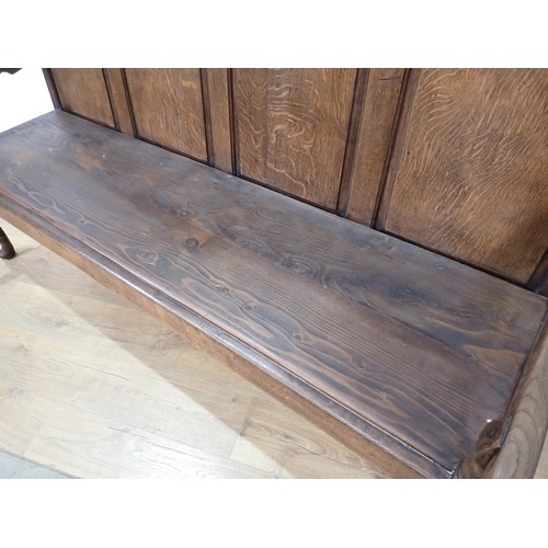 362 - An antique oak Settle with fielded panelled back on slender cabriole front supports and replacement ... 