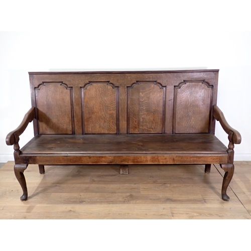 362 - An antique oak Settle with fielded panelled back on slender cabriole front supports and replacement ... 