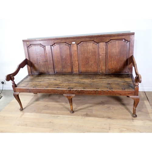 446 - An 18th Century oak Settle with fielded four panel back mounted upon three cabriole front supports 6... 