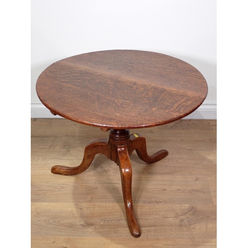 467 - An 18th Century oak low Pillar Table with circular tilt top mounted upon turned elm column on tripod... 