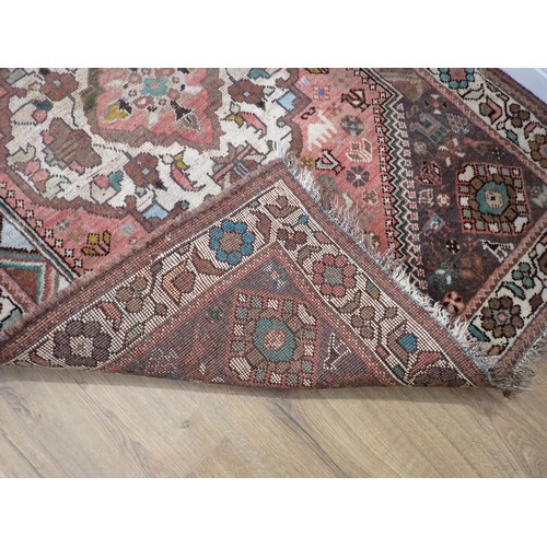 246 - A small Persian Rug with animal and floral motifs on a red ground, 5ft 4in x 3ft 7in