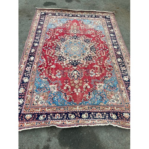 776 - A pink ground woollen Rug with blue stylised designs 9ft 6in L x 6ft 5in W