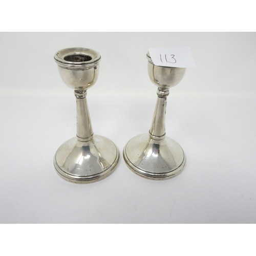 113 - A pair of George V silver Candlesticks on circular bases, Birmingham 1926, A/F