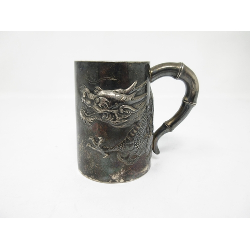 115 - A Chinese silver Mug embossed and chased with finely detailed dragon, simulated bamboo handle, marke... 