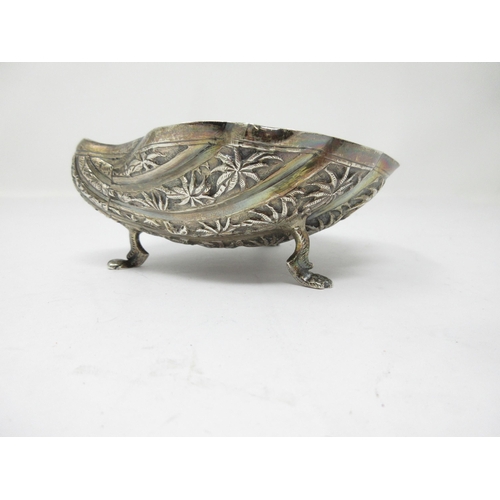 121 - An Eastern silver scallop shape Dish decorated palm trees, etc