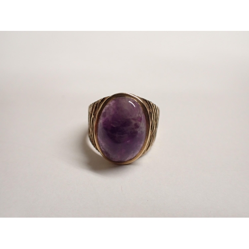 156 - A 9ct gold textured Ring set oval purple cabochon, ring size R