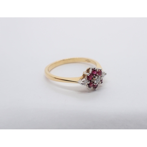 189 - A Diamond and Ruby Flower Cluster Ring claw-set brilliant-cut diamond within a frame of six round ru... 