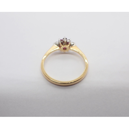 189 - A Diamond and Ruby Flower Cluster Ring claw-set brilliant-cut diamond within a frame of six round ru... 