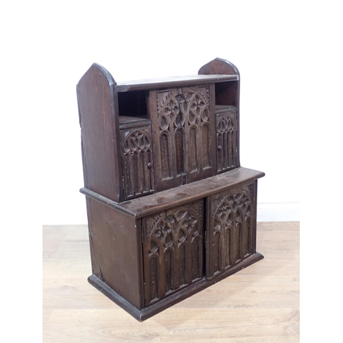 254 - A small oak Cupboard with gothic tracery style carving with two small cupboard doors above a larger ... 