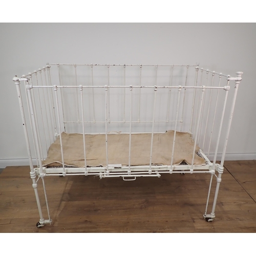 277 - A Victorian white painted iron Cot with drop side on on casters, 4ft 5in x 2ft 6in