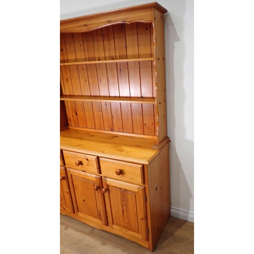 303 - A modern pine Kitchen Dresser and Rack the base fitted three frieze drawers above three cupboard doo... 