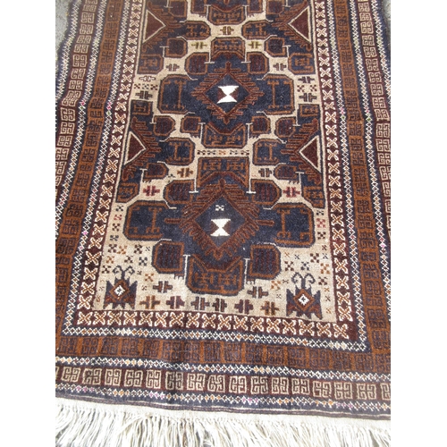 306 - A modern beige ground Rug with three navy stylised flower heads within multiple borders 6ft 6in L x ... 