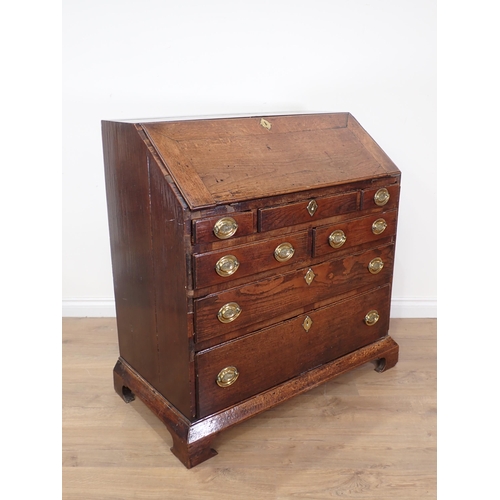 452 - A Georgian oak Bureau with fall front enclosing fitted interior above five short and two long drawer... 