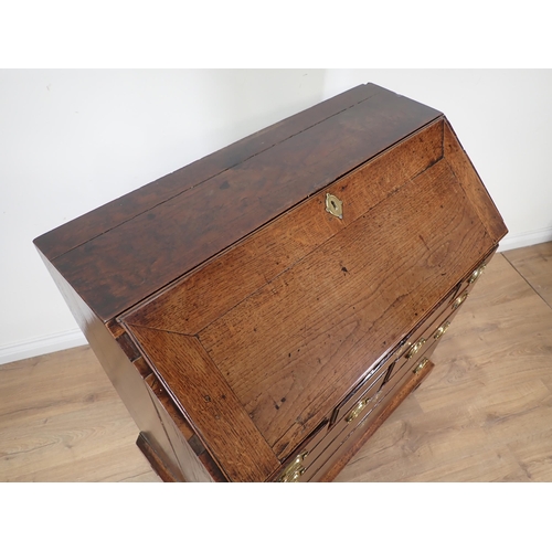 452 - A Georgian oak Bureau with fall front enclosing fitted interior above five short and two long drawer... 