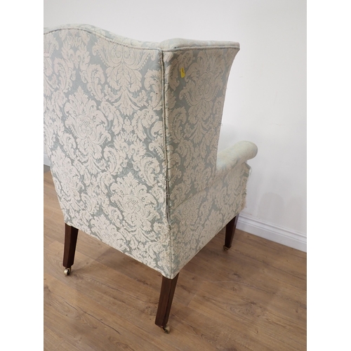 472 - A 19th Century wingback Armchair on square cut tapering supports and casters