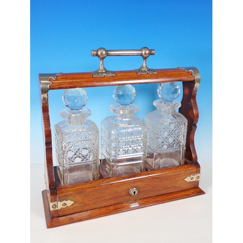 5 - An oak Tantalus with three Decanters