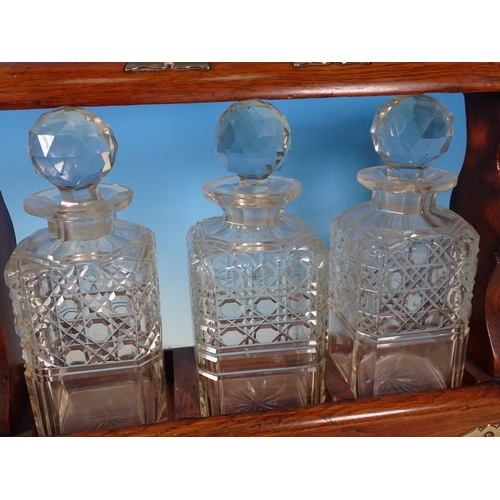 5 - An oak Tantalus with three Decanters