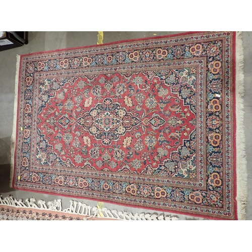 524 - A Persian red ground Rug with floral design around central blue lozenge within tramline border 4ft 5... 